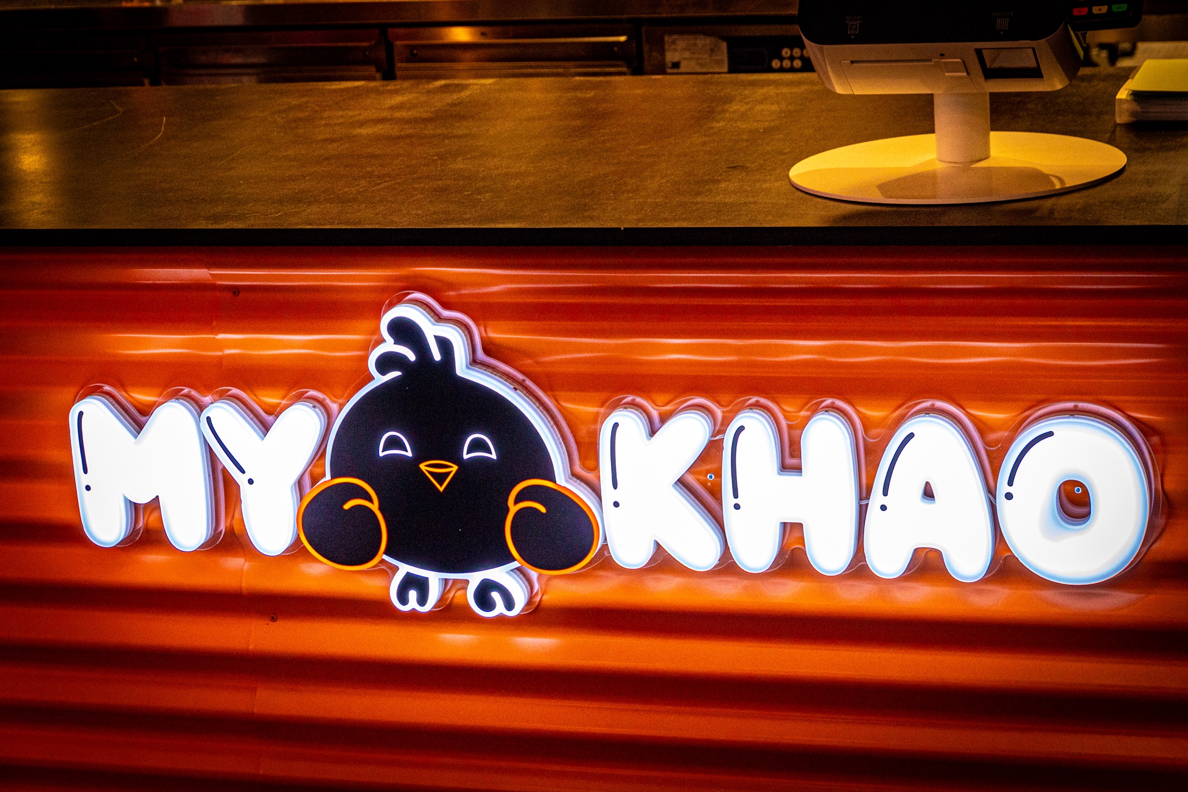Enseigne lumineuse My Khao et mascotte sur le comptoir