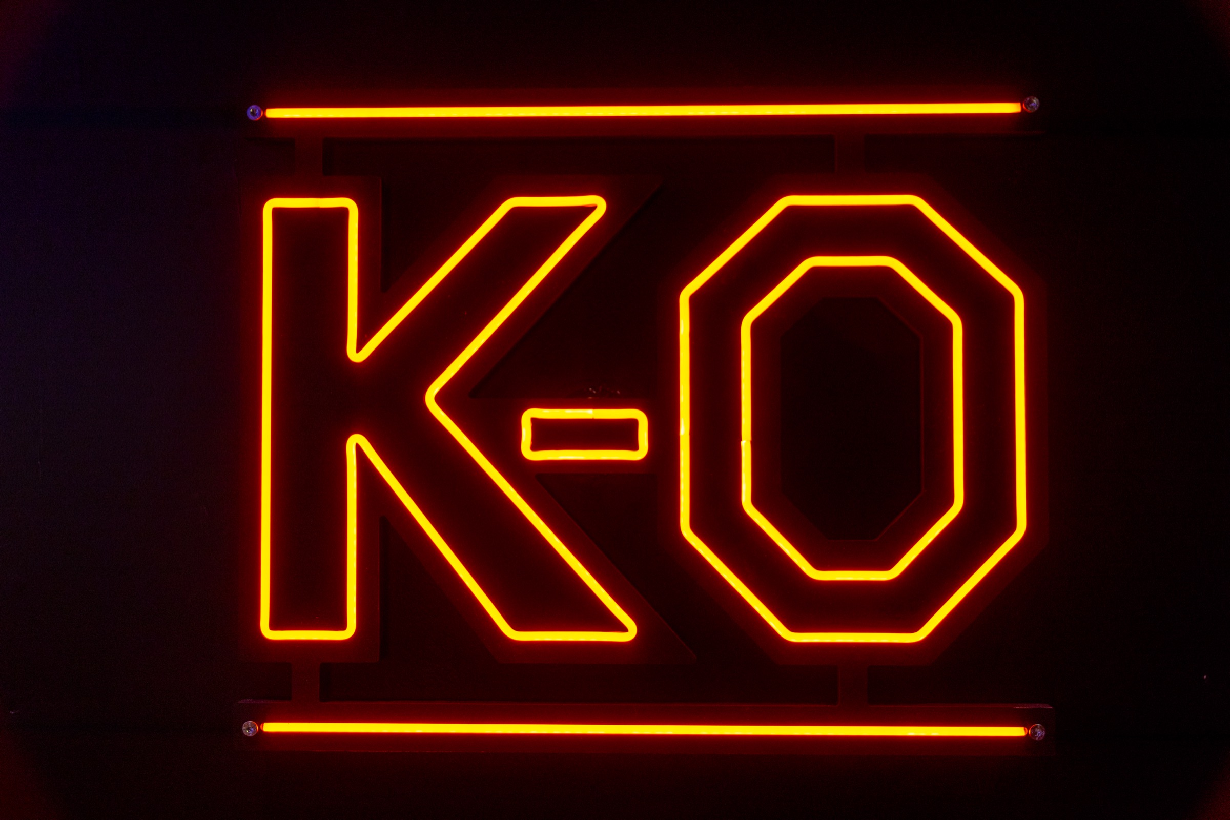 Enseigne néon K.O. orange sur fond noir