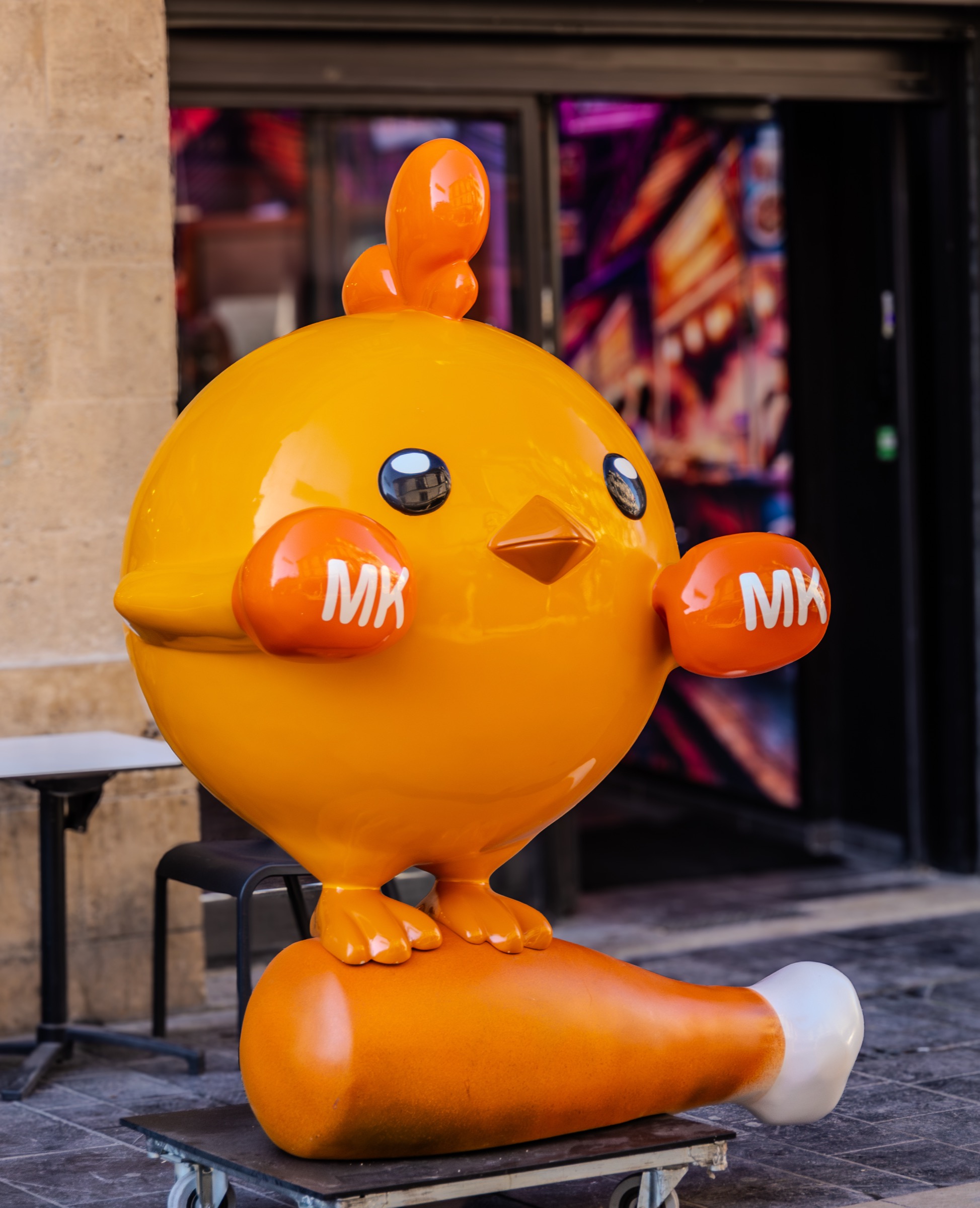 Grande mascotte orange My Khao devant l'entrée du restaurant
